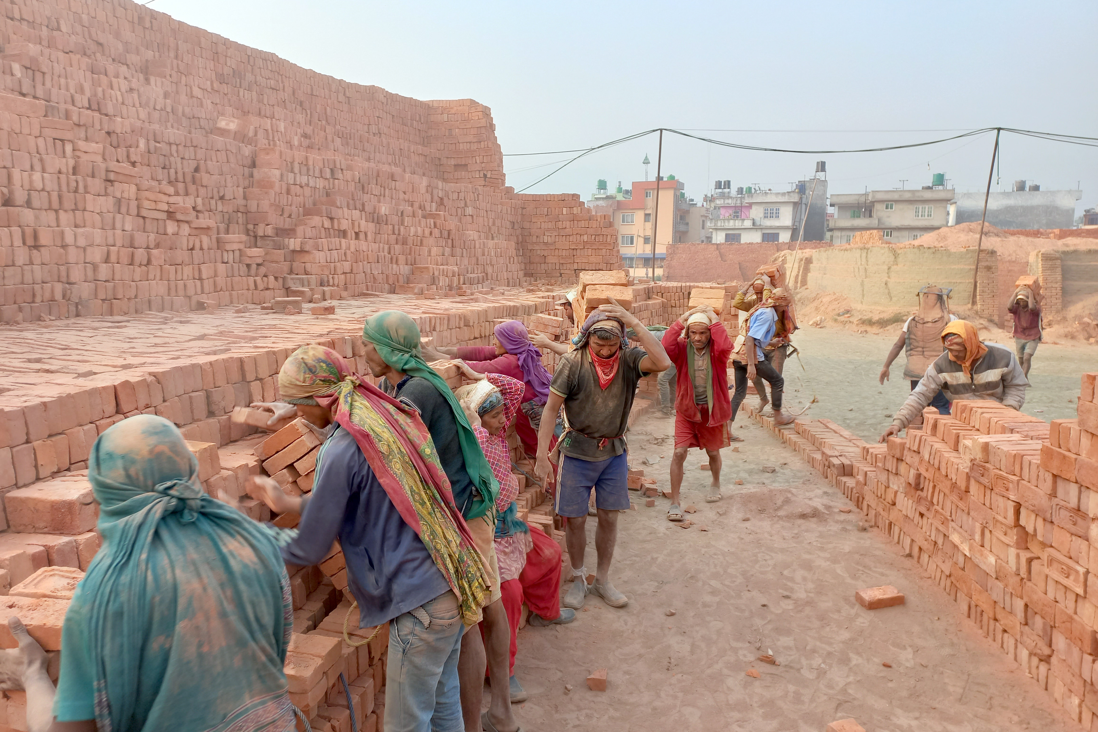 इँट्टा चाङ लगाउन र बोक्न व्यस्त श्रमिक